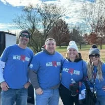 A group of friends posing together in Hero Run shirts