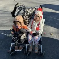 Two toddlers bundled up in a wagon at the event