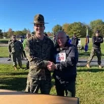 A drill instructor presenting an award to a participant