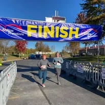 Runners crossing under the finish line banner