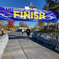 Runners crossing under the finish line banner
