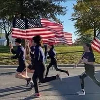 A group running together while carrying American flags