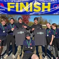 A group of young volunteers holding shirts and medals